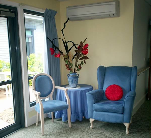 Two chairs and a table in a corner make a pleasant resting spot in a dementia-friendly environment
