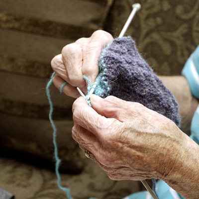 An older woman knitting - knitting is a purposeful activity for people with dementia.